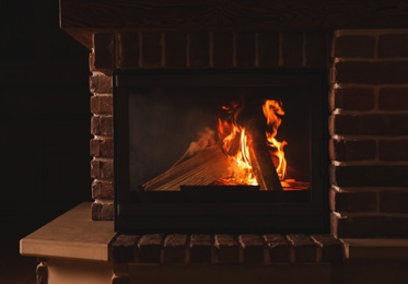 Photo of Fireplace with burning wood indoors. Winter vacation