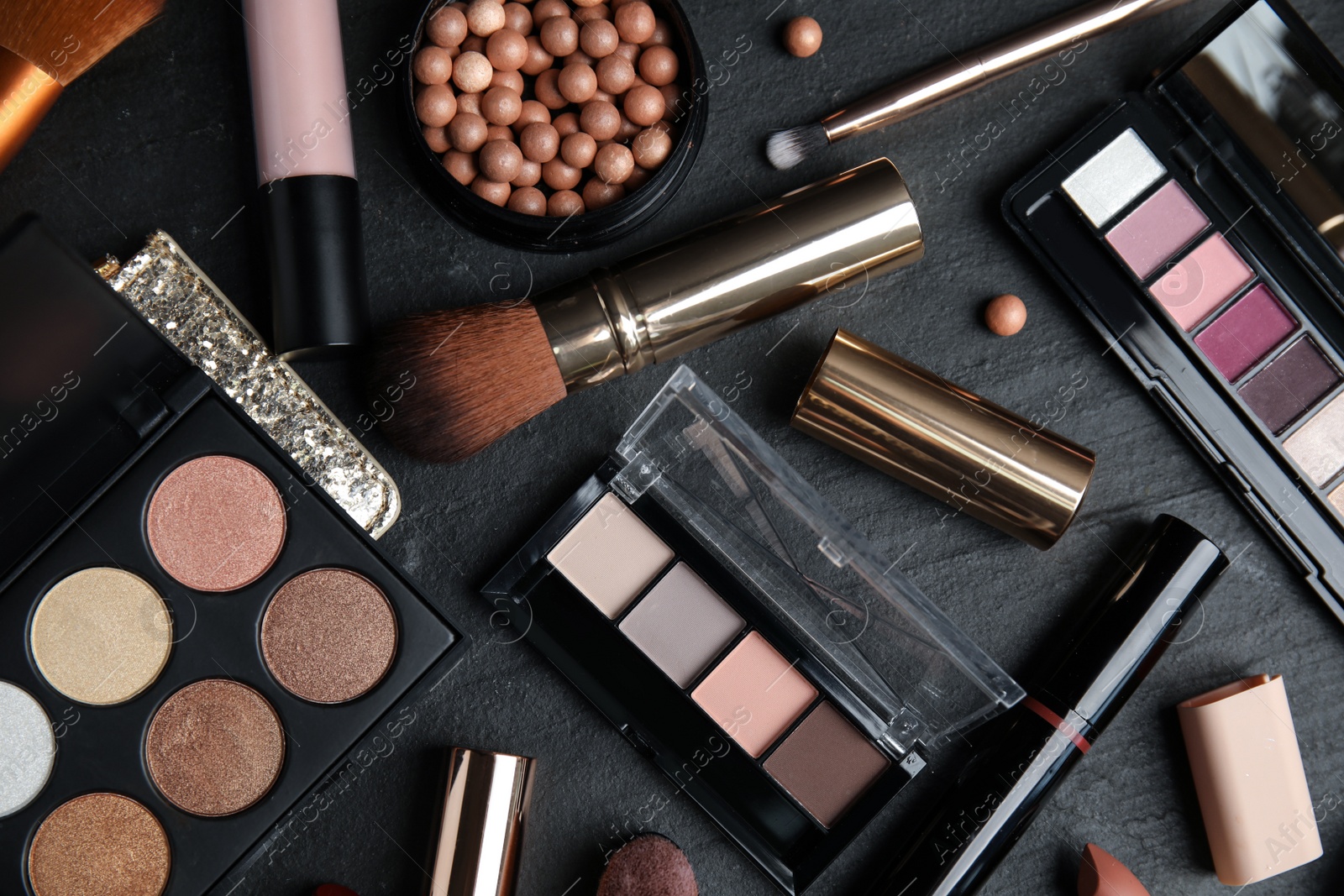 Photo of Flat lay composition with makeup products on black slate table