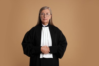 Photo of Beautiful senior judge in court dress on light brown background