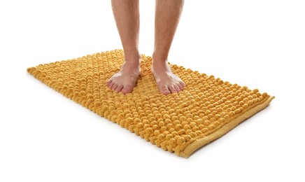 Man standing on soft orange bath mat against white background, closeup