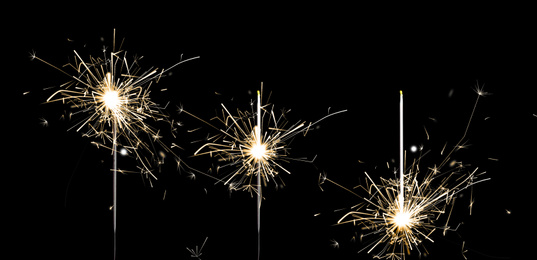 Image of Set of burning sparklers on black background. Banner design