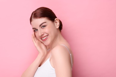 Photo of Portrait of smiling woman on pink background. Space for text