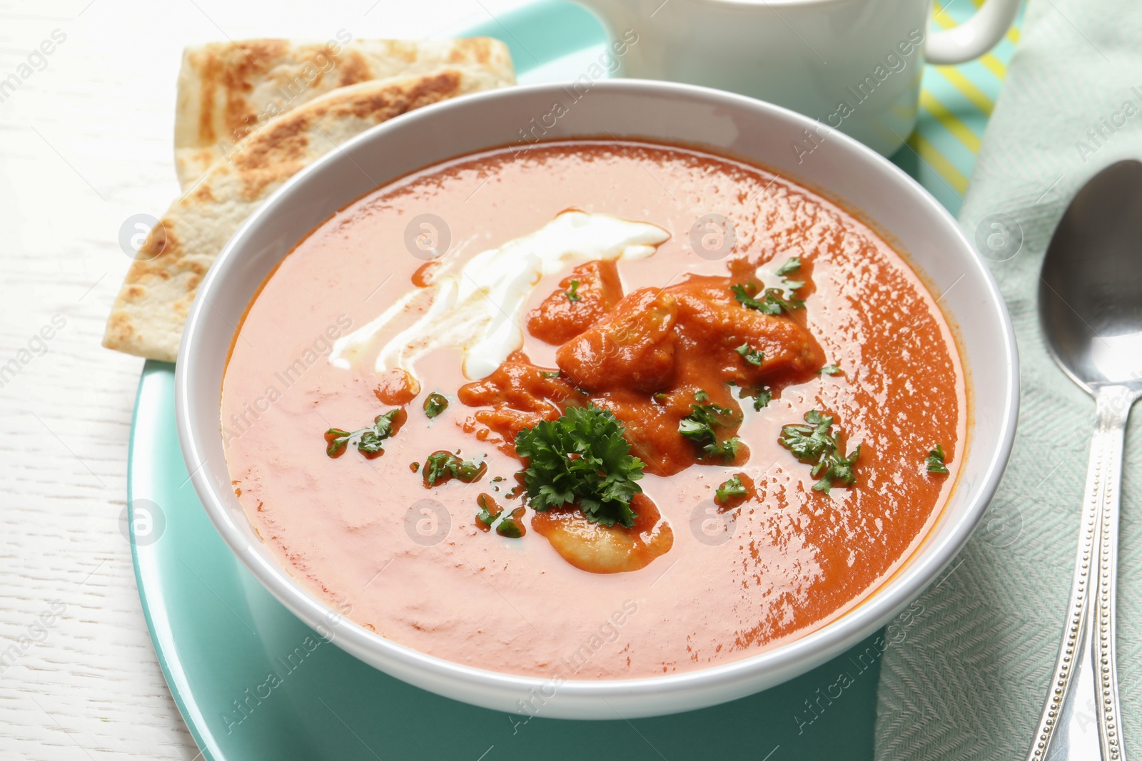 Photo of Delicious butter chicken in bowl served on table. Traditional Murgh Makhani dish