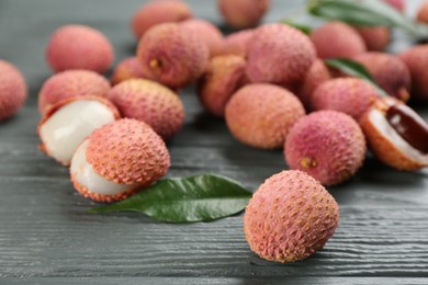 Fresh ripe lychee fruits on grey wooden table, closeup