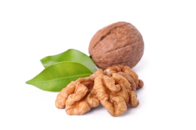 Walnut in shell, kernels and green leaves on white background