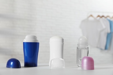 Photo of Different deodorants on white table in room