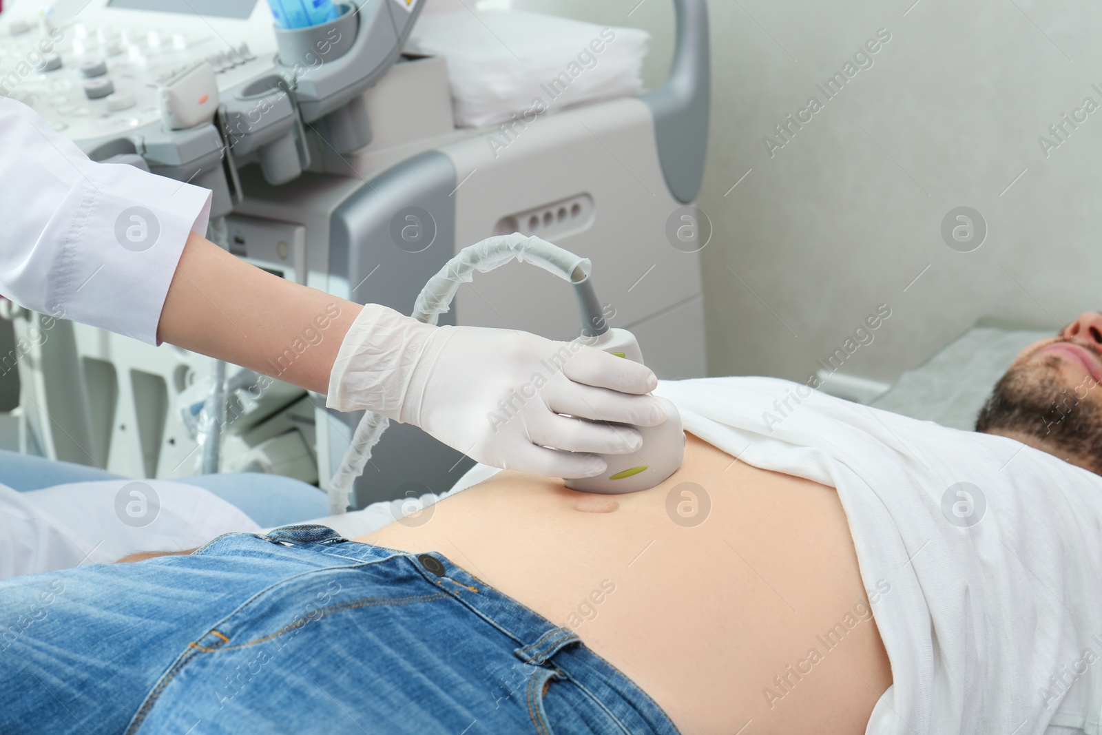 Photo of Doctor conducting ultrasound examination of internal organs in clinic, closeup