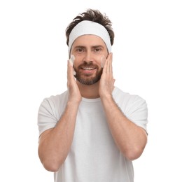 Man with headband washing his face on white background