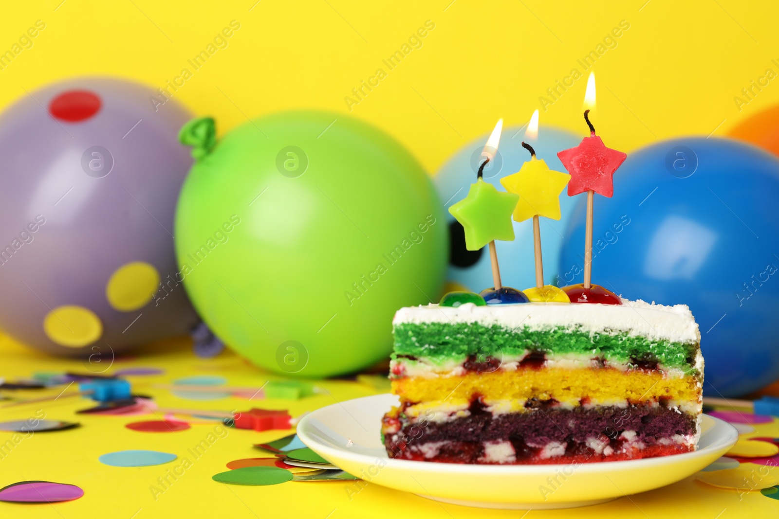 Photo of Piece of birthday cake with candles on yellow background, space for text