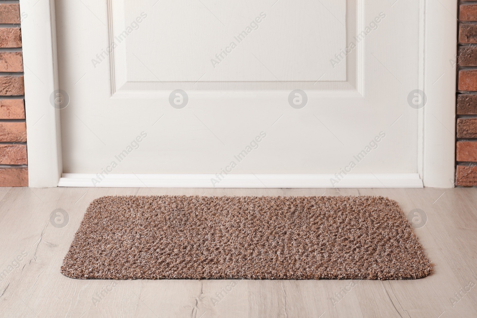 Photo of Grey door mat on wooden floor in hall