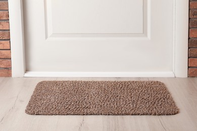 Grey door mat on wooden floor in hall