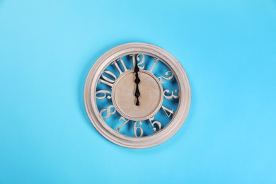 Photo of Stylish wall clock on turquoise background, top view