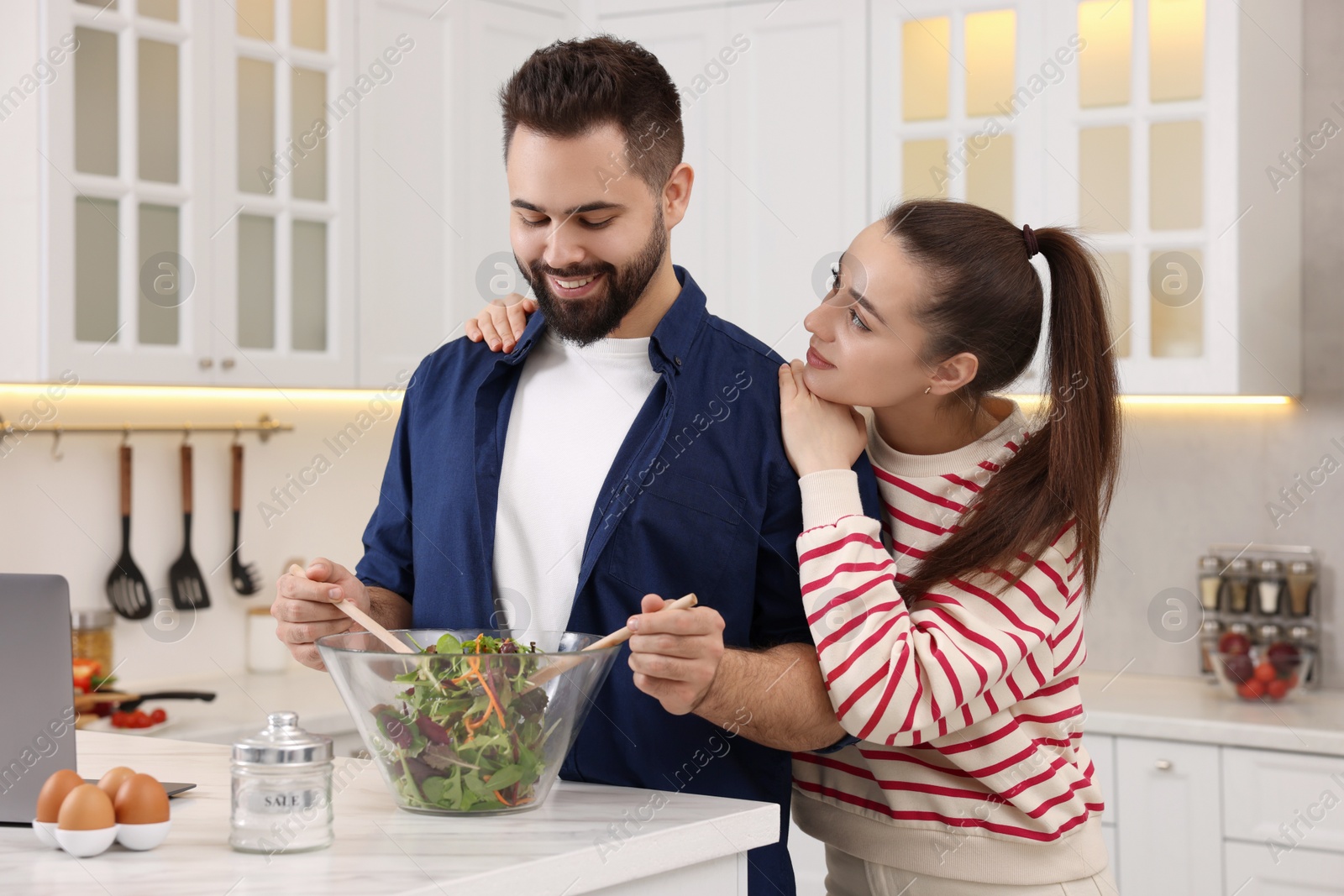 Photo of Happy lovely couple cooking together in kitchen