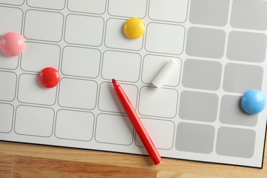 Timetable. Planner, felt pen and drawing pins on wooden table, top view