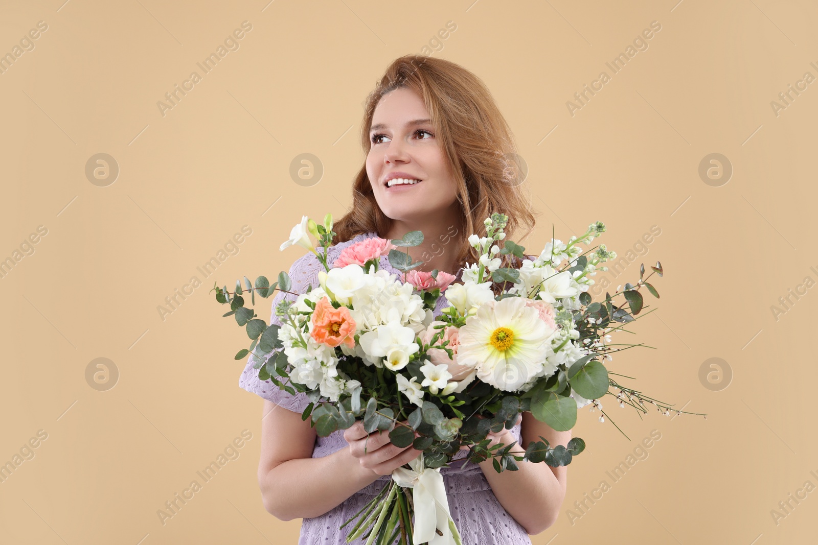 Photo of Beautiful woman with bouquet of flowers on beige background