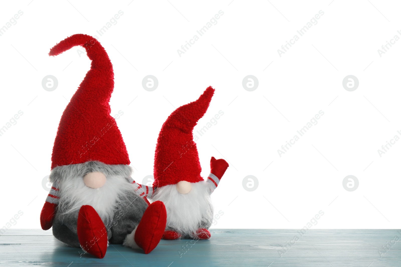 Photo of Funny Christmas gnomes on turquoise wooden table against white background. Space for text