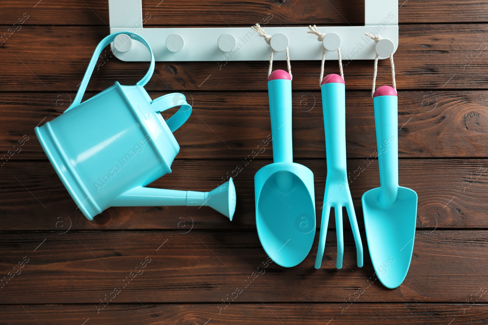 Photo of Set of professional gardening tools hanging on wooden wall