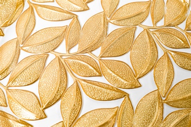 Photo of Many gold leaves on white background, top view