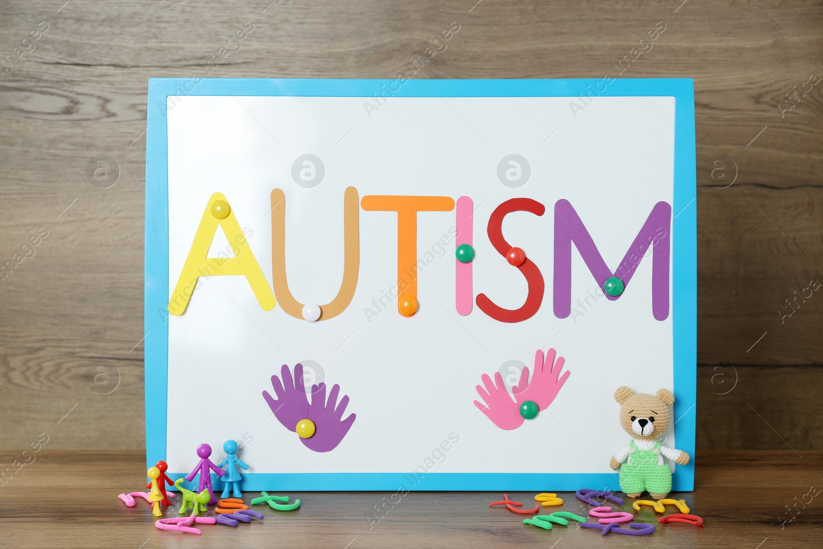 Photo of MYKOLAIV, UKRAINE - DECEMBER 30, 2021: Magnetic board with word Autism and toys on wooden table