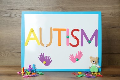 MYKOLAIV, UKRAINE - DECEMBER 30, 2021: Magnetic board with word Autism and toys on wooden table