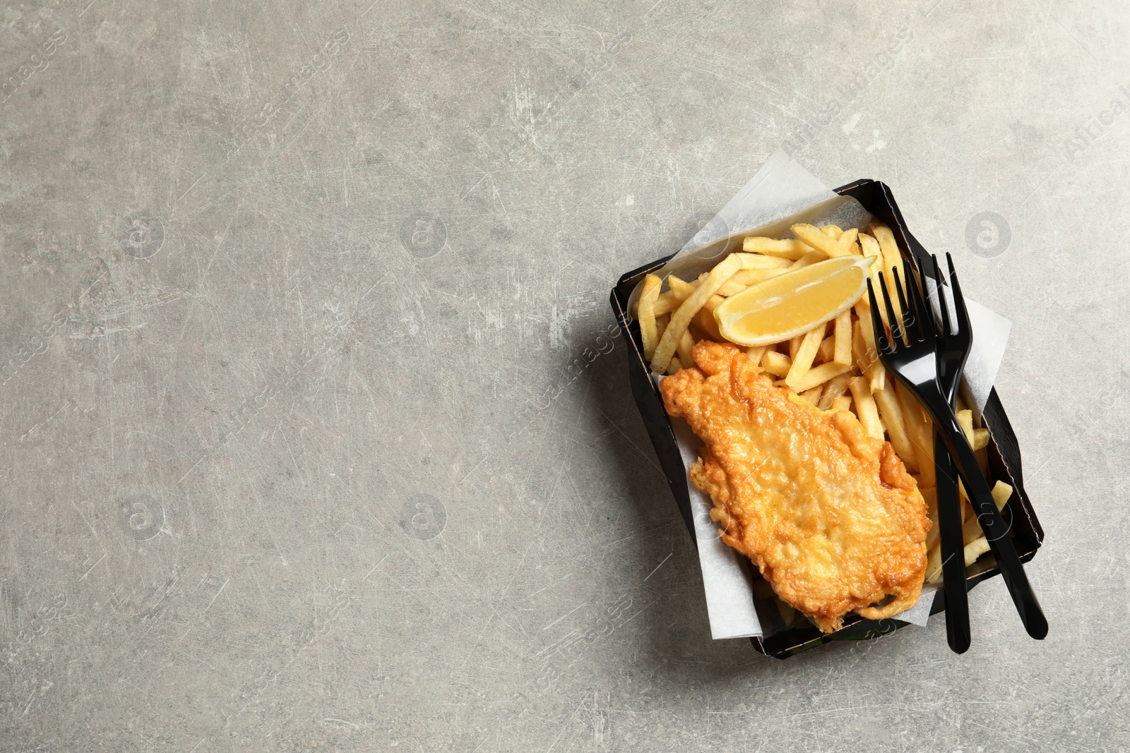 Photo of Disposable container with British Traditional Fish and potato chips on grey background, top view. Space for text