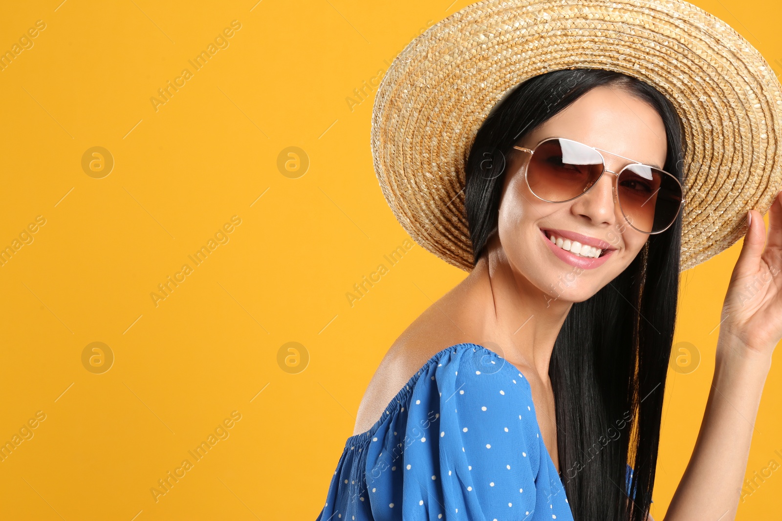 Photo of Beautiful woman wearing sunglasses on yellow background. Space for text