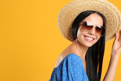 Photo of Beautiful woman wearing sunglasses on yellow background. Space for text