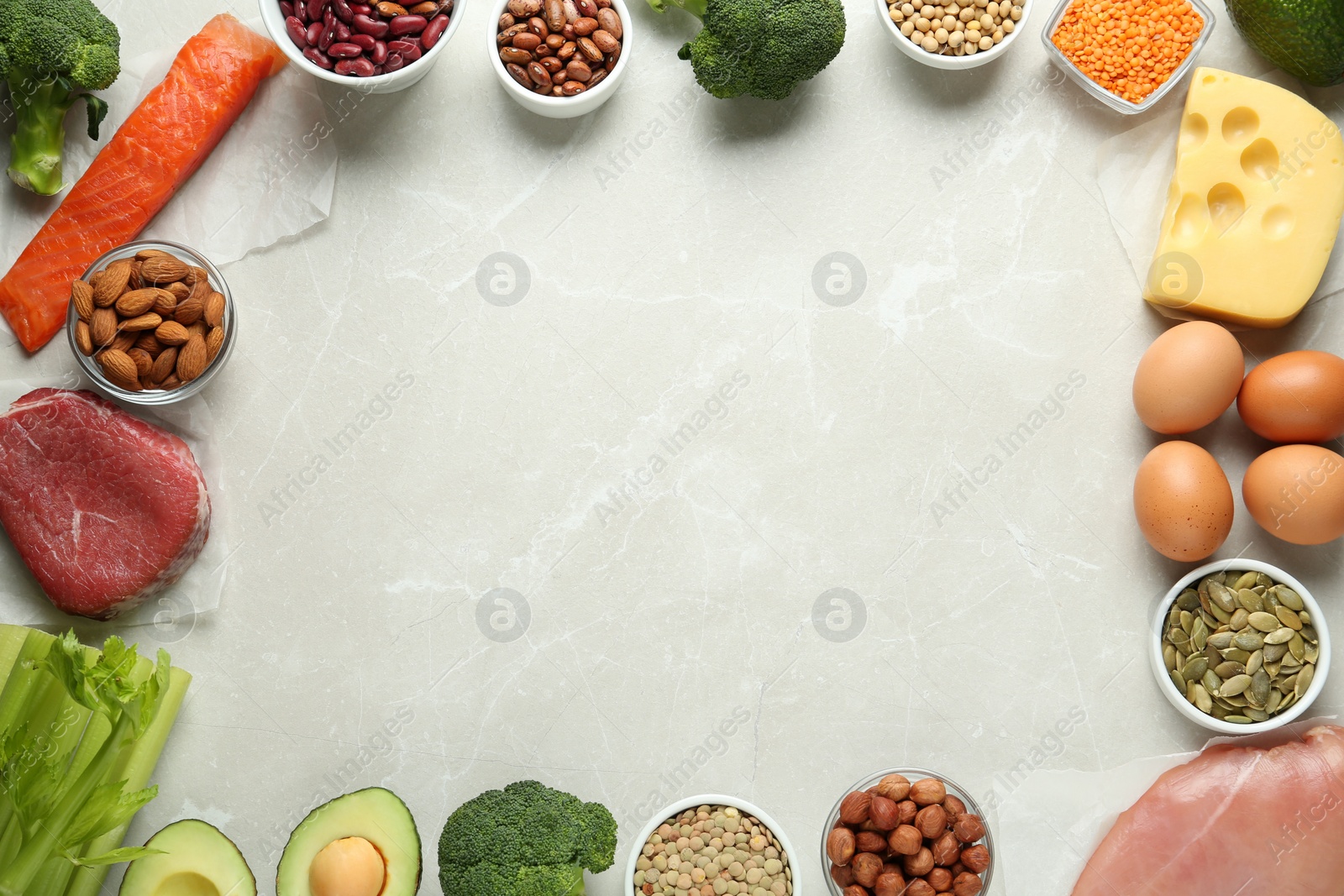 Photo of Frame of products rich in amino acids on light grey table, flat lay. Space for text