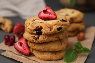 Photo of Cookies with freeze dried fruits, mint and nuts on grey table, closeup