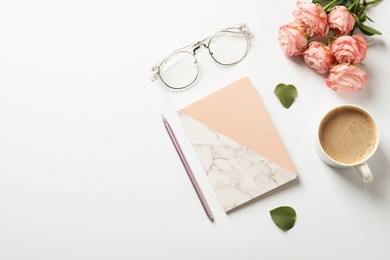 Photo of Flat lay composition with book, flowers and cup of coffee on white background. Space for text