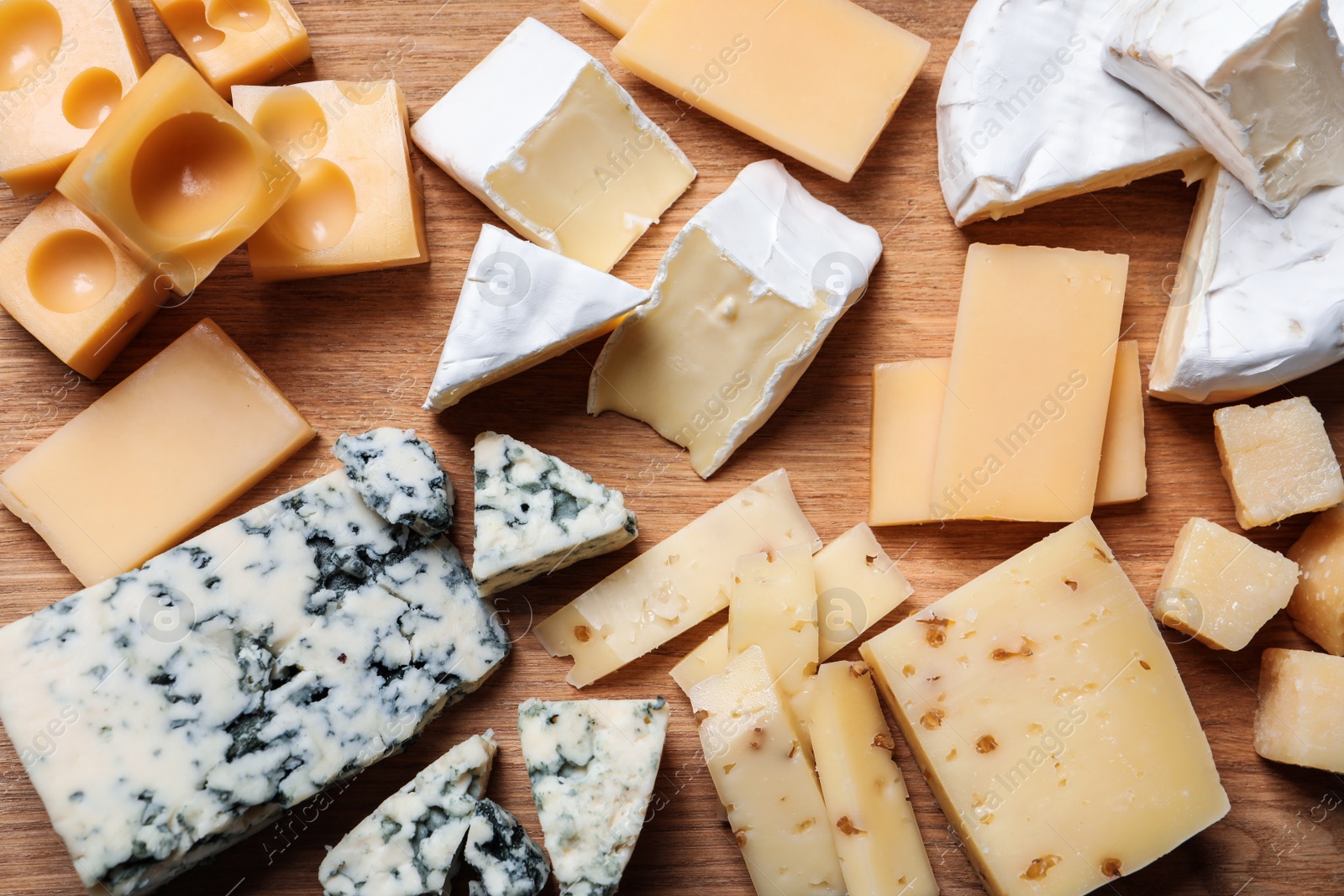 Photo of Cheese plate on wooden board, top view