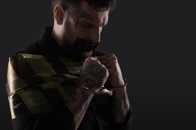 Man taped up and taken hostage on dark background. Space for text