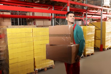 Photo of Worker with cardboard boxes in warehouse, space for text. Wholesaling