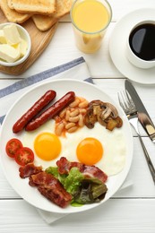 Delicious breakfast with sunny side up eggs served on white wooden table, flat lay