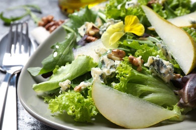 Photo of Fresh salad with pear on table, closeup