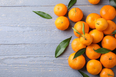 Fresh ripe tangerines on grey wooden table, flat lay. Space for text