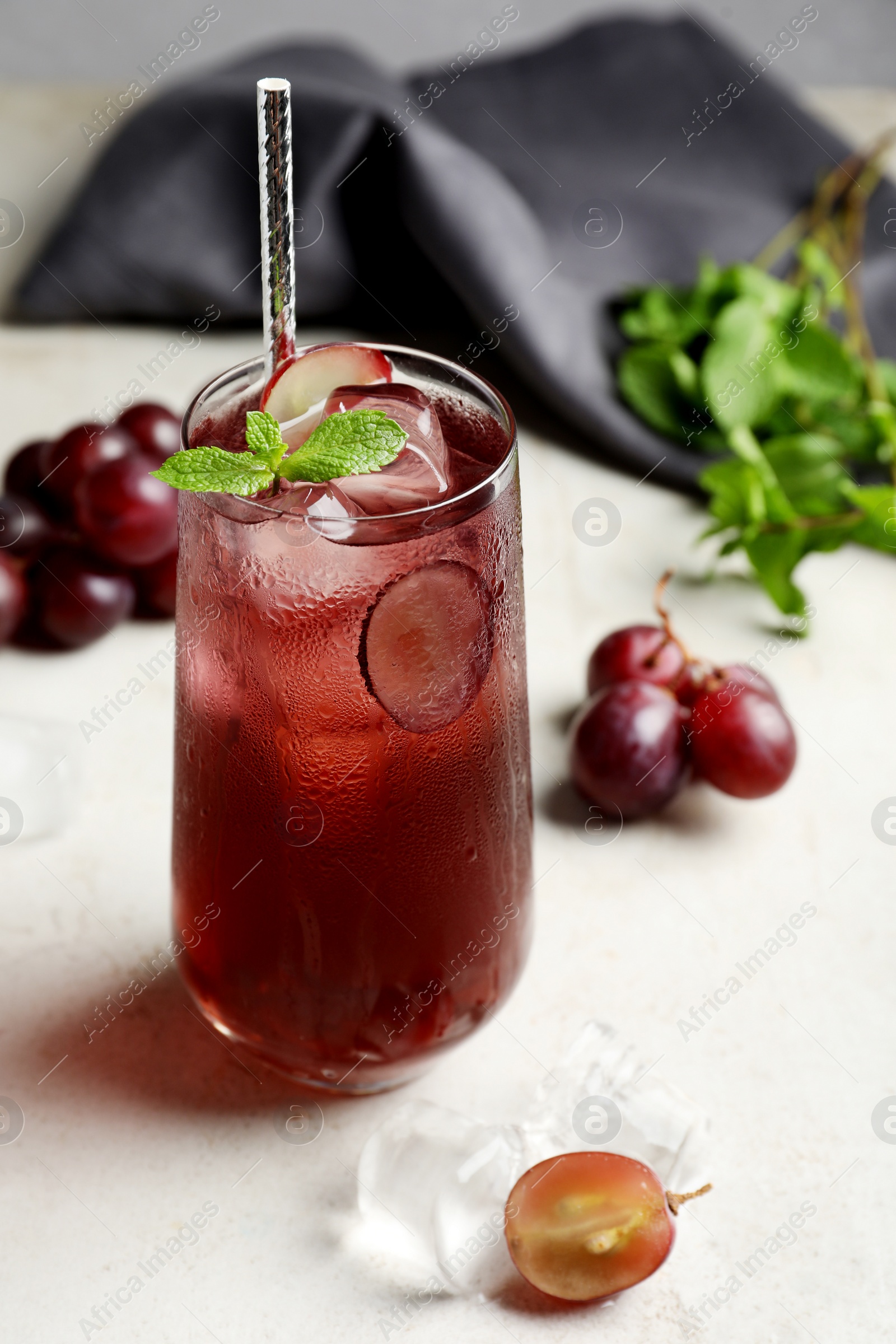 Photo of Delicious grape soda water with mint on white table. Refreshing drink