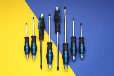 Photo of Set of screwdrivers on color background, flat lay