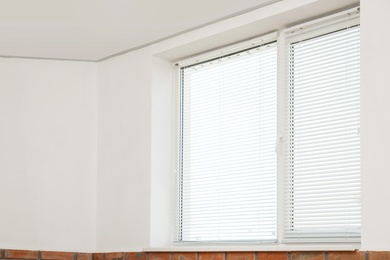 Photo of New modern window with blinds indoors. Home interior