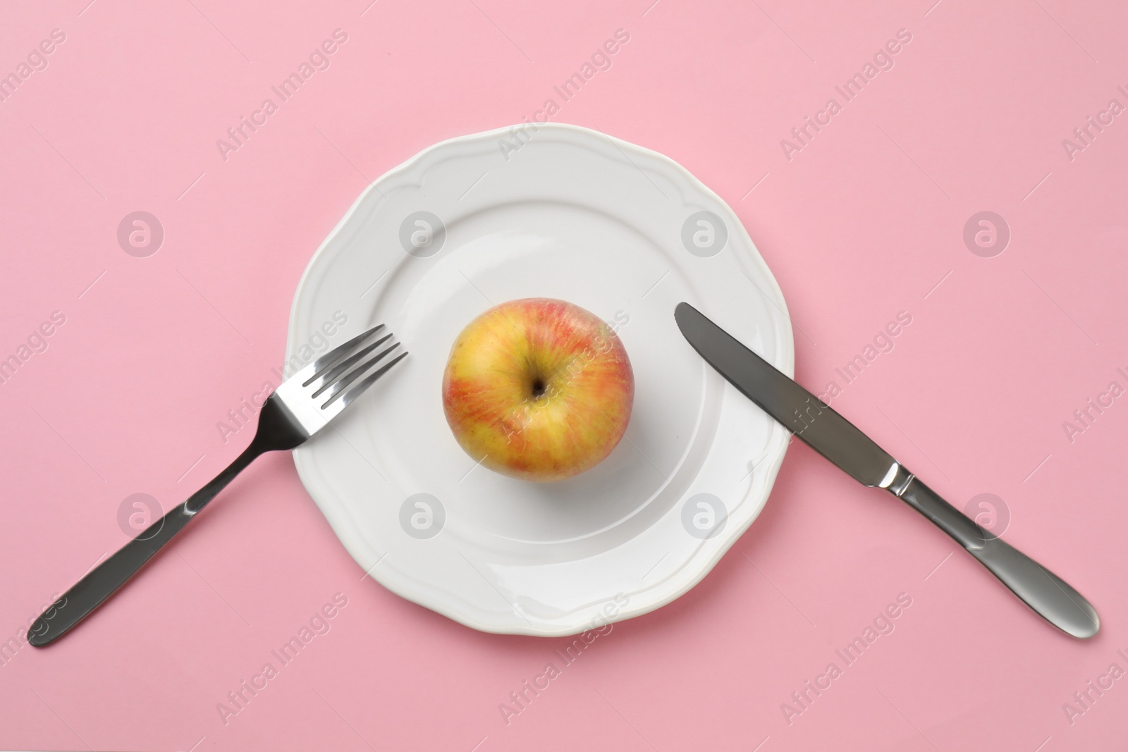 Photo of Plate with fresh apple and cutlery on color background, top view. Healthy diet