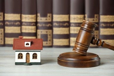 Construction and land law concepts. Judge gavel, house model with books on wooden table