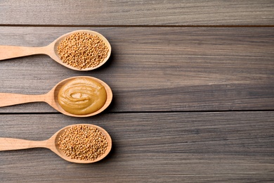 Flat lay composition with mustard seeds on wooden table. Space for text