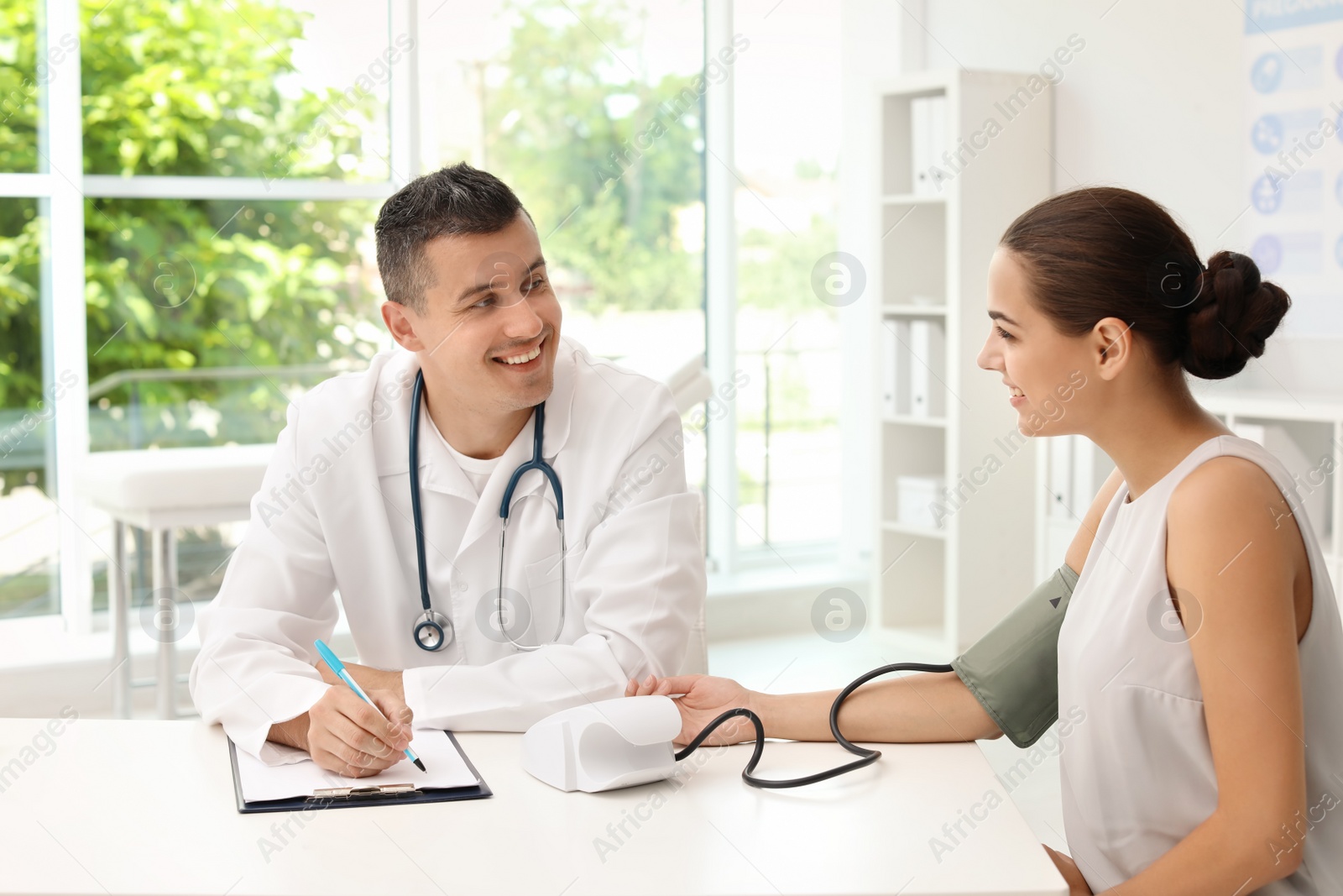 Photo of Doctor checking patient's blood pressure in hospital