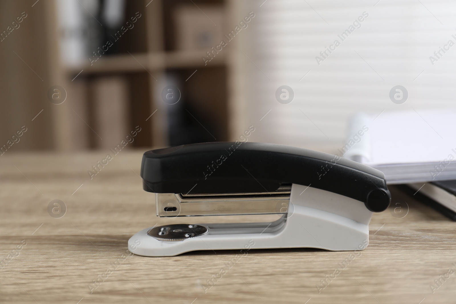 Photo of One stapler on wooden table indoors, closeup