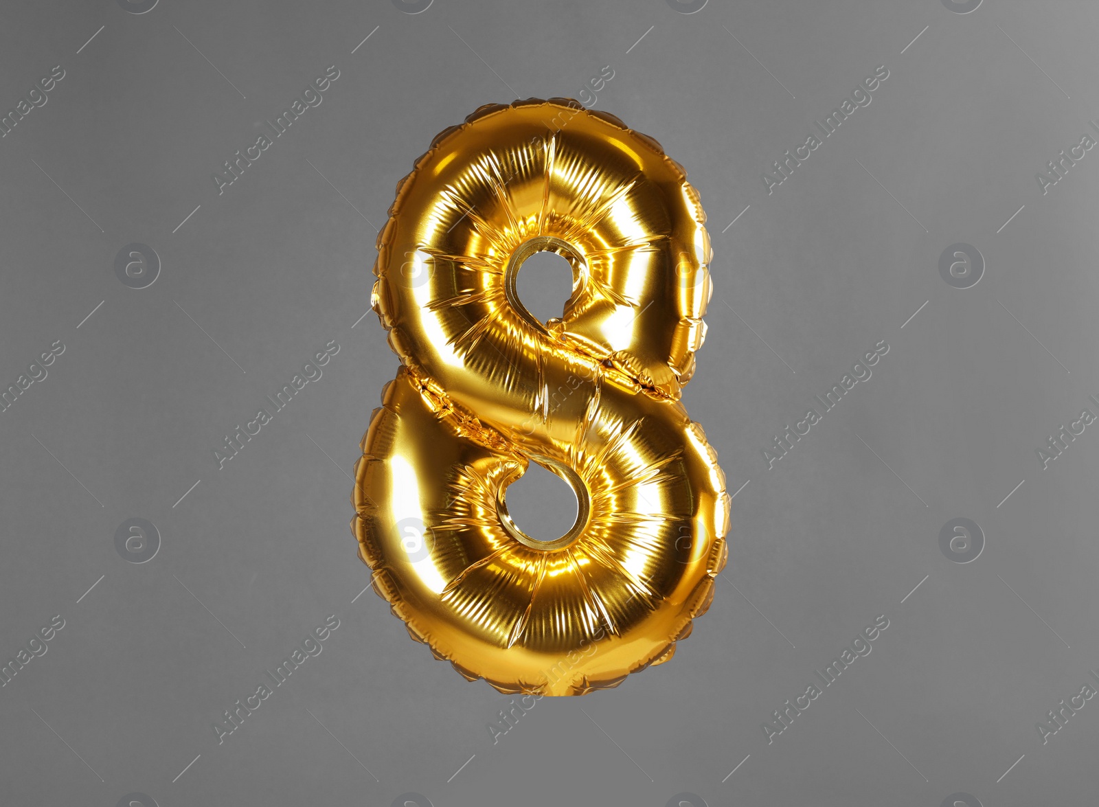Photo of Golden number eight balloon on grey background