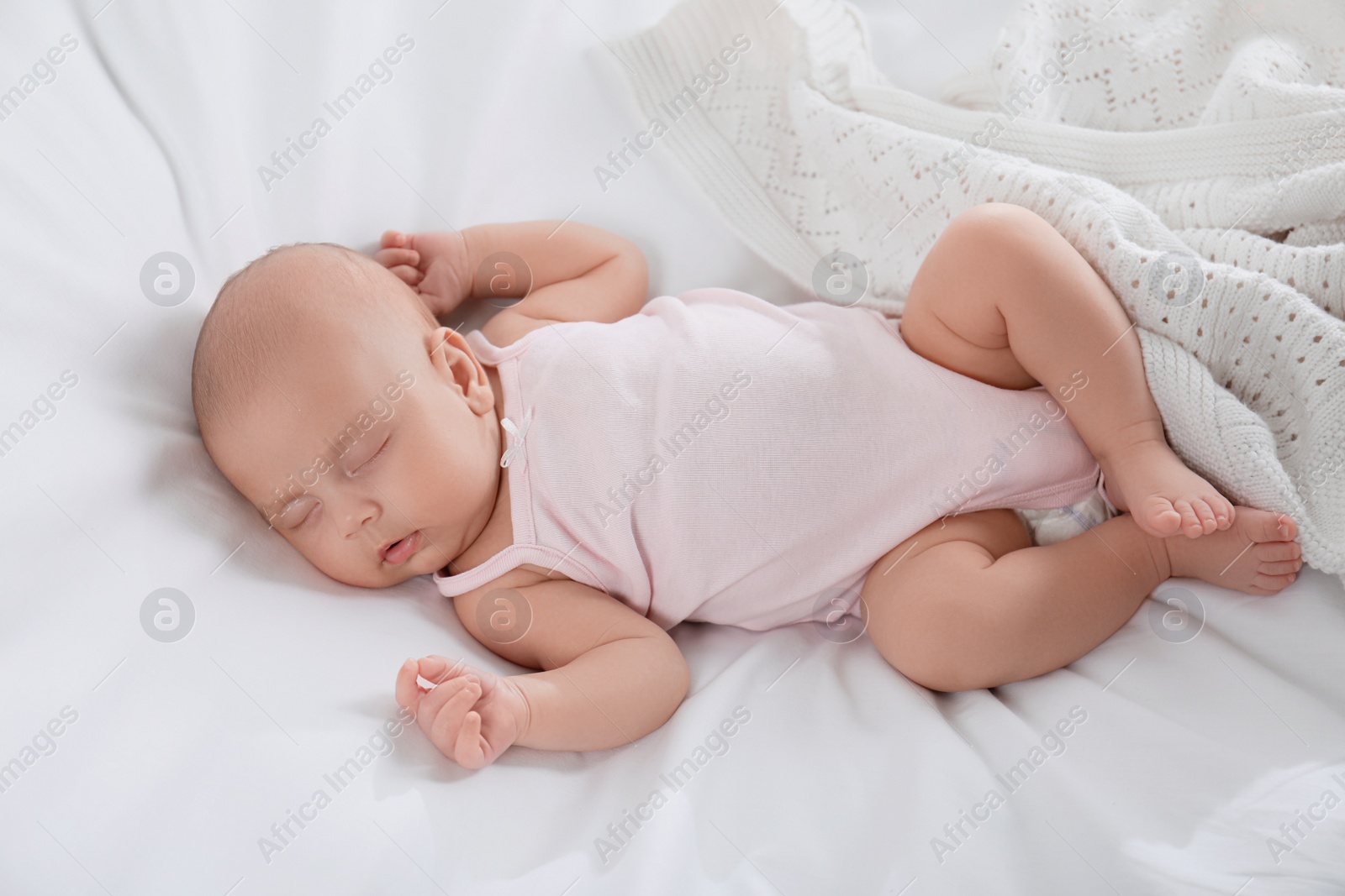 Photo of Cute little baby sleeping on bed, above view