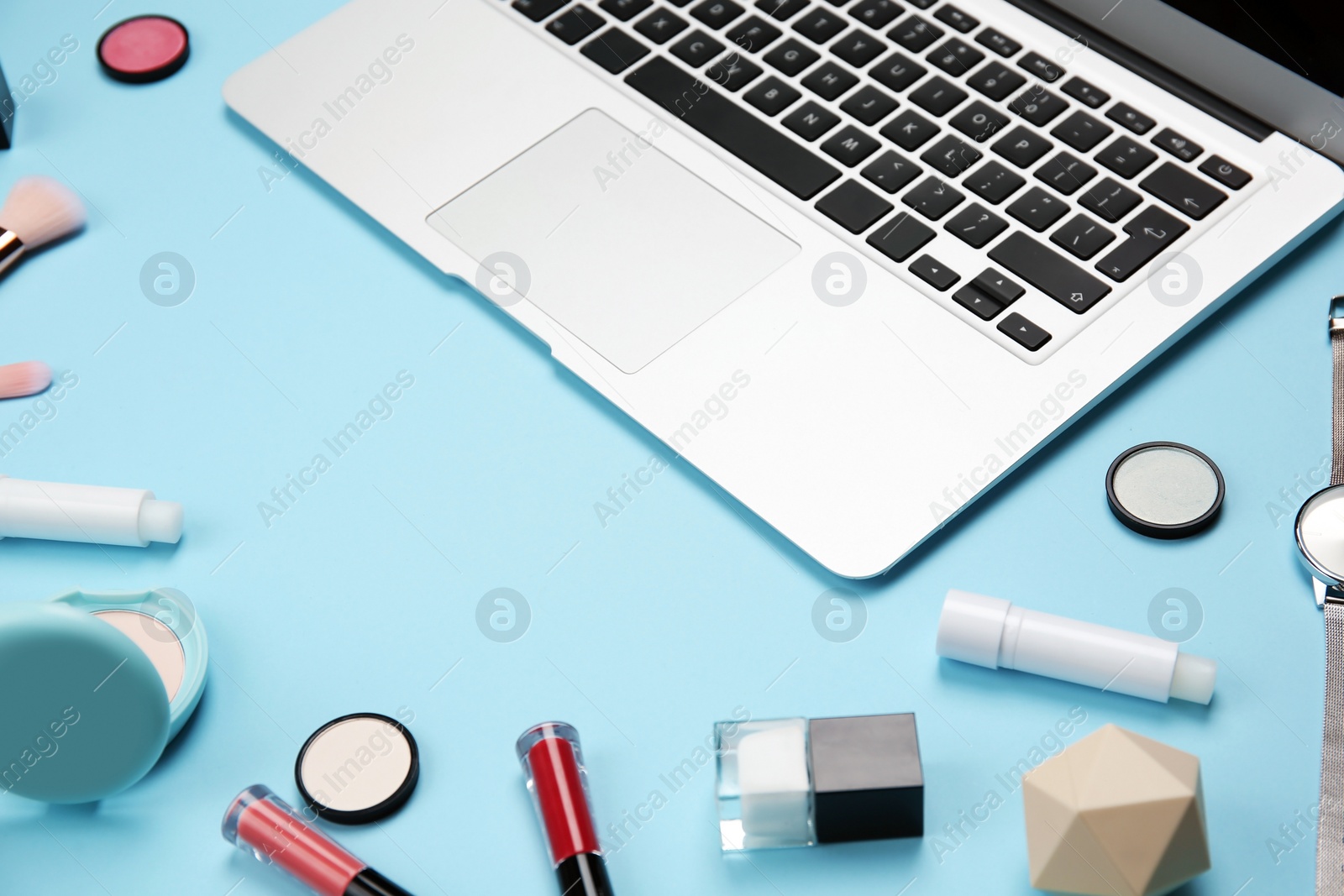Photo of Composition with laptop and makeup products for woman on color background