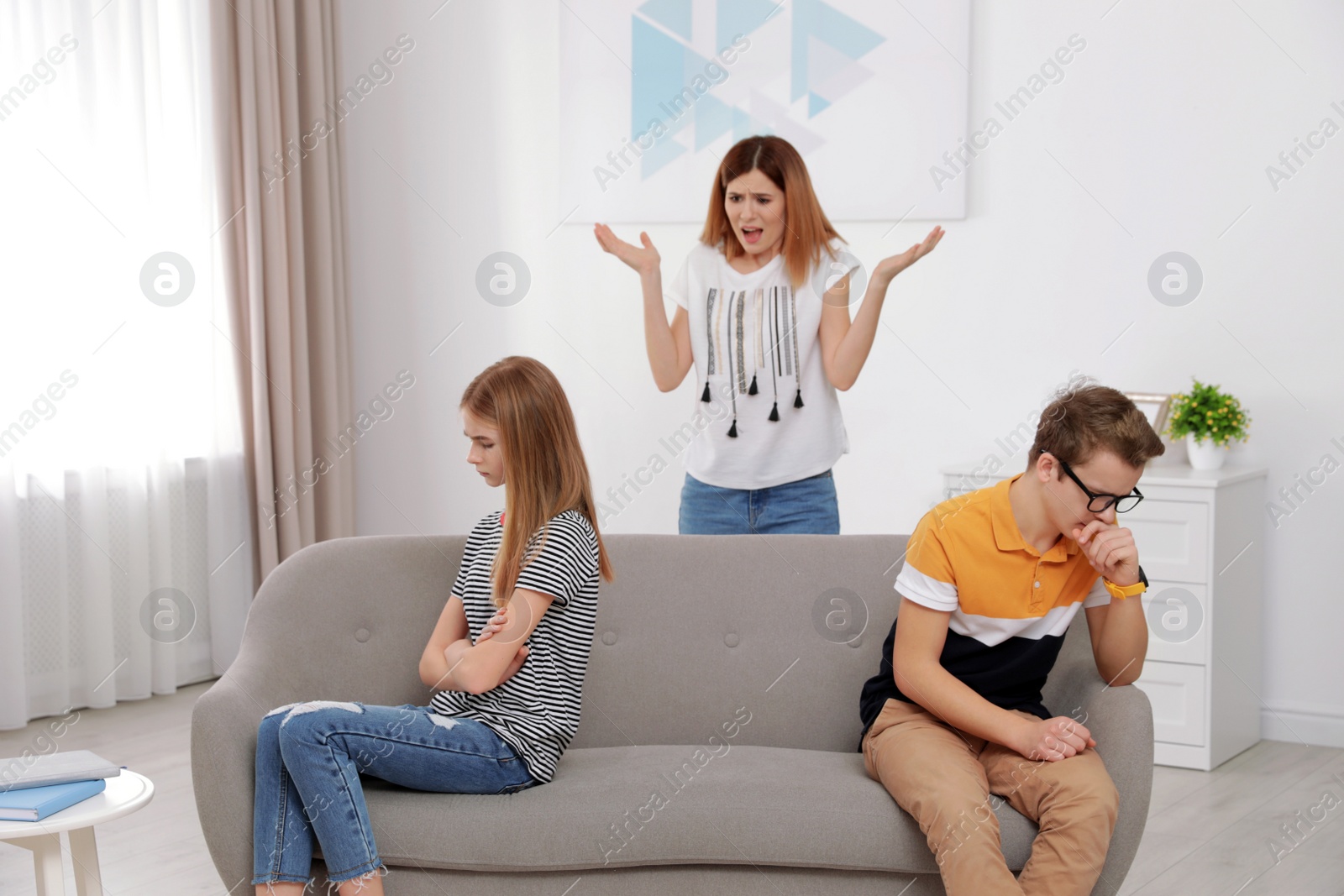 Photo of Mother scolding her teenager daughter and son at home