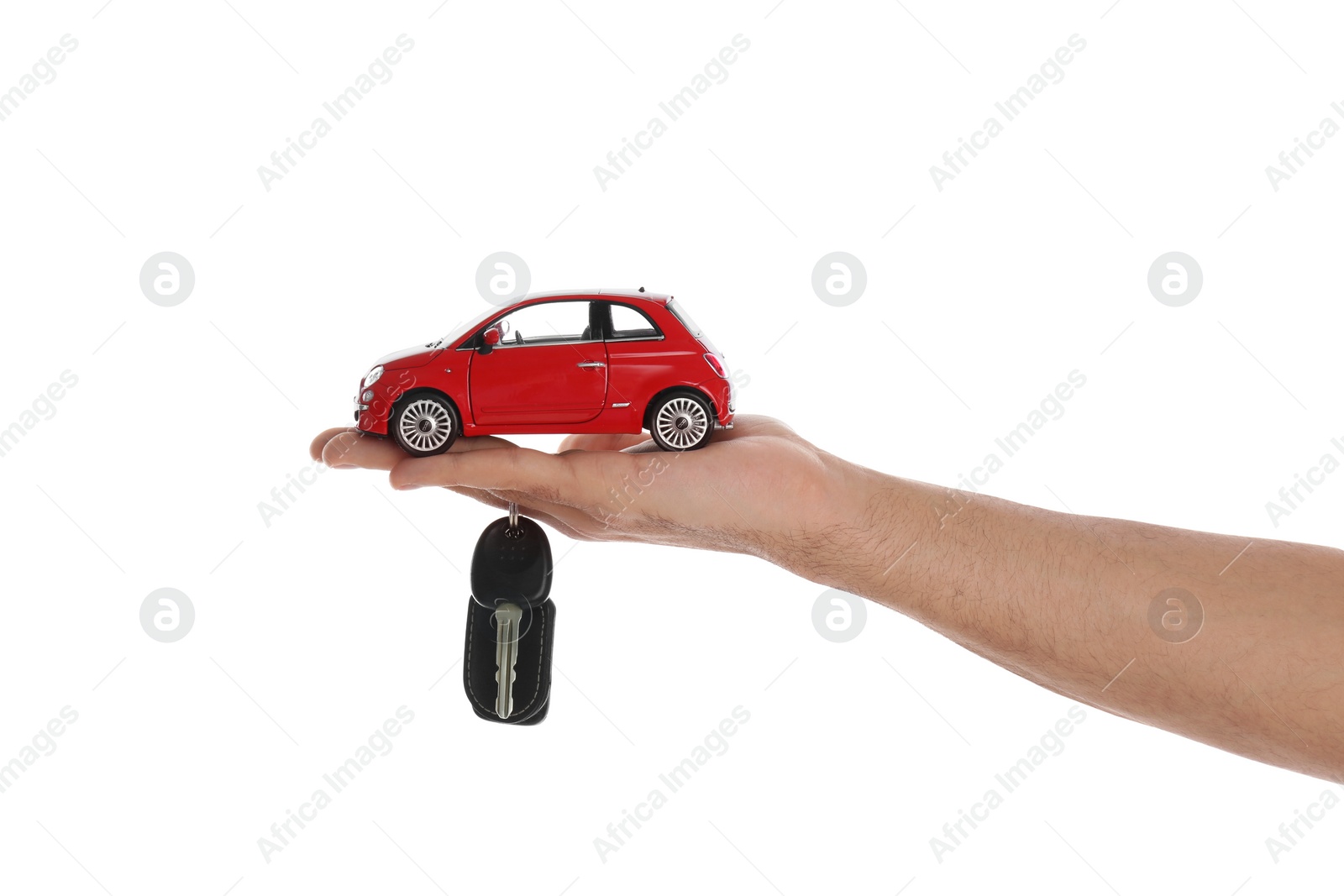 Photo of Man holding key and miniature automobile model on white background, closeup. Car buying