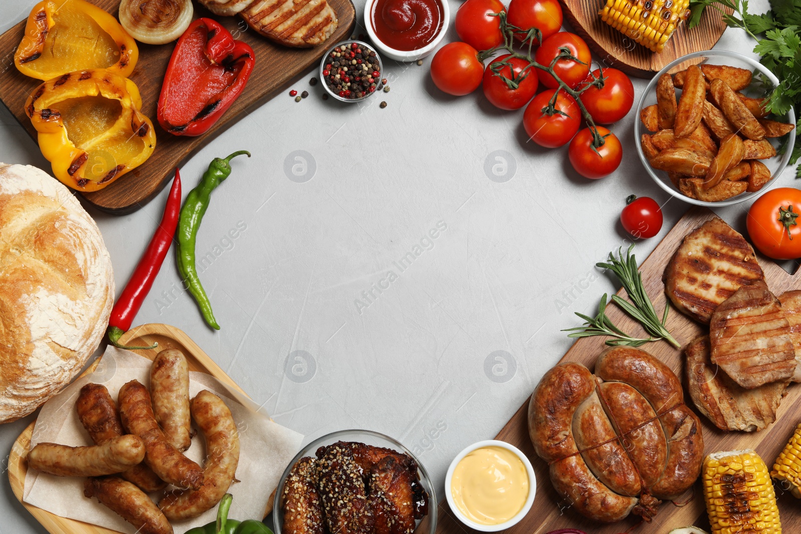 Photo of Frame of barbecued meat and vegetables on light table, flat lay. Space for text